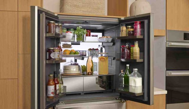 Front view of a modern kitchen with an opened LG Signature refrigerator Front view of a modern kitchen with an opened LG Signature refrigerator