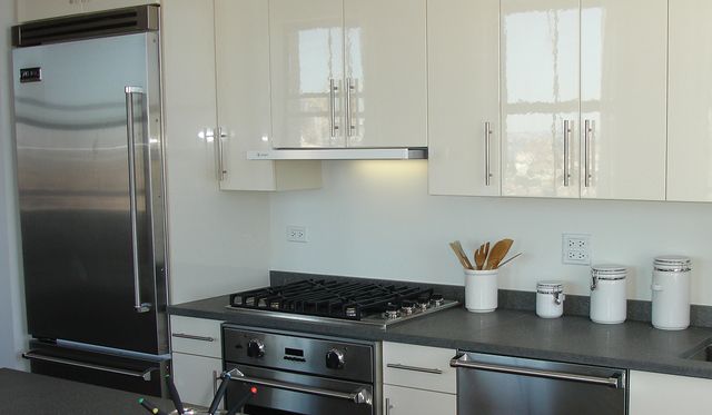Front view of a modern kitchen with a Faber insert range hood over the stove