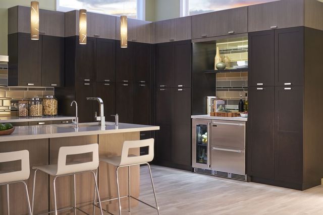 front view of a contemporary kitchen with refrigerator drawers built into brown cabinetry