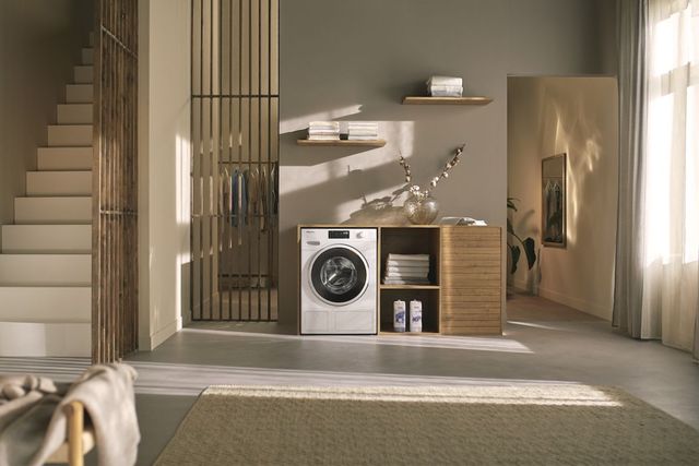 Front view of a modern laundry room with a Miele Energy Star washer