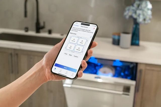 Front view of a phone being held up on front of a Thermador dishwasher to control its wash1