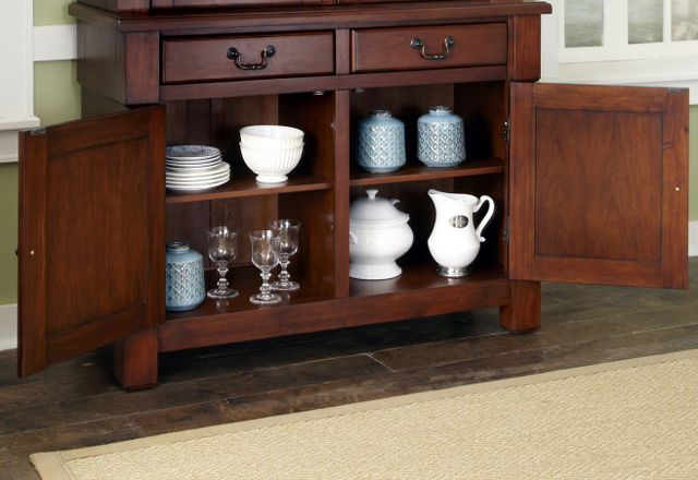 front view of a transitional dining room cabinet with both lower doors open showing dinnerware inside