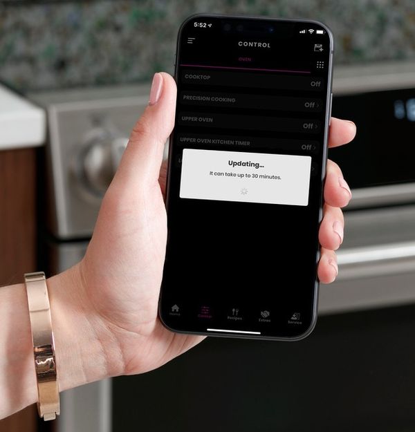 person using smart app with stove person using smart app with stove