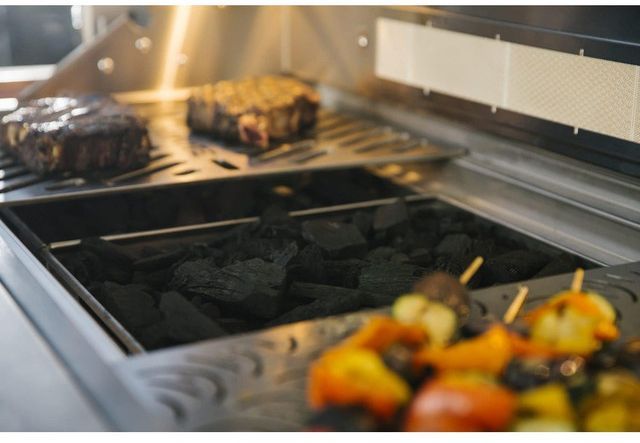 front view of a grill-smoker combo with mean cooking on it