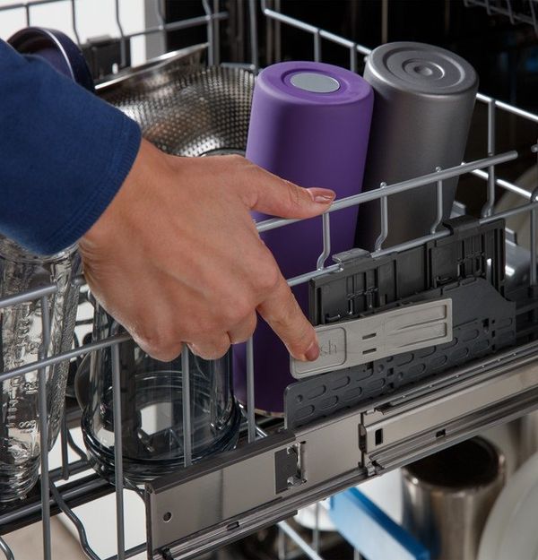 A fully loaded GE Profile dishwasher with plates, bowls, and glasses on the adjustable racks.