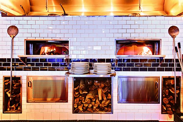 Front view of two Wood Stone wood pizza ovens built into a white tile wall