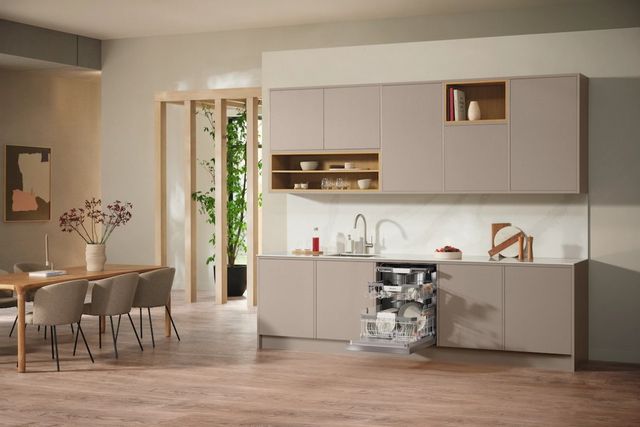 View of a modern kitchen with beige walls and cabinetry, with an opened Miele dishwasher