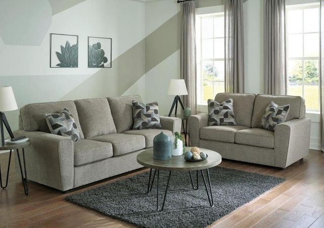 front view of a modern living room with a beige sofa and loveseat set