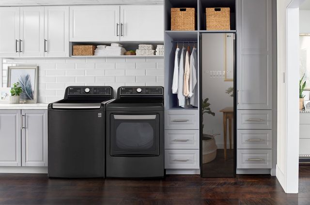 front view of a modern laundry room with a black lg top load washer and dryer 