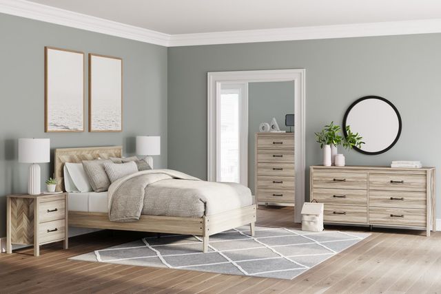 Front view of a coastal bedroom with airy design, light blue walls, and light wooden accents.