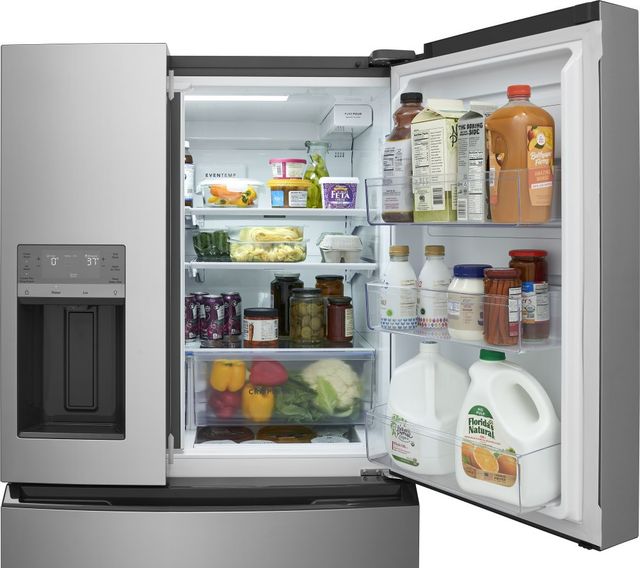Open Frigidaire refrigerator showing adjustable shelving and crisper drawers full of fresh produce Open Frigidaire refrigerator showing adjustable shelving and crisper drawers full of fresh produce