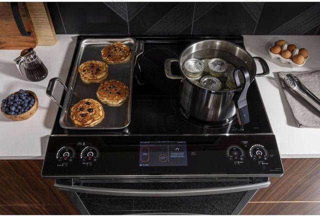 standing view of a slide in range with a pancake tray one one side and a pot for preserving jars on the other
