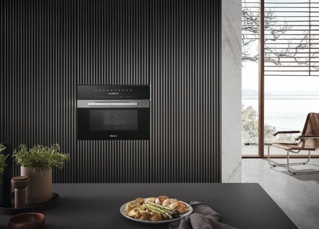 Front view of a Miele wall oven microwave combo in a luxury kitchen wall