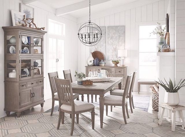 front view of a modern dining room with a rectangular table, six chairs, a tall dining hutch on the left, and a sideboard in the background